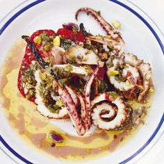 an octopus dish is served on a white plate