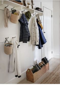 the coat rack is filled with coats and shoes on it's hooks, along with other items