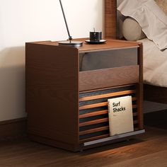 a small wooden nightstand with a cup on it