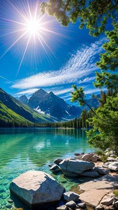 the sun shines brightly over a mountain lake with rocks and trees in front of it