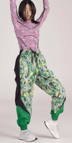 Show your summer colors in the vibrant and colorful adidas by Stella McCartney Printed Woven Track Pants. Mixing floral-inspired prints with graphic color-blocked inserts, these track pants are sure to make a statement. Made from 100% recycled polyester, these track pants are a testament to our effort to end plastic waste. You can leave the house with your small essentials thanks to the pockets, and the waistband is easily adjusted with a drawcord. Wear the loose-fitting track pants on your way to the studio and keep them on to brunch after. This product is a pair of green woven track pants from the collaboration between Stella McCartney and Adidas. The pants feature a colorful print, drawstring closure, and are made of polyester. They are designed for women in a regular fit and size mediu Adidas Collaboration, Sporty Adidas Cotton Pants, Track Pants Adidas, Adidas Green Sportswear Bottoms, Adidas Cotton Track Pants, Stella Mccartney Adidas, Active Wear Pants, Sport Pants, Summer Colors