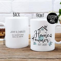 two white coffee mugs sitting on top of a wooden table