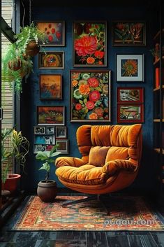 an orange chair sitting in front of a blue wall with pictures on it and a potted plant