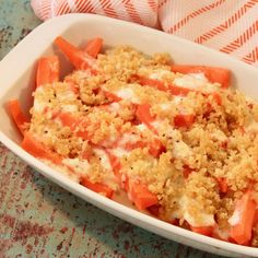 a casserole dish with carrots and crumbs in it on a table