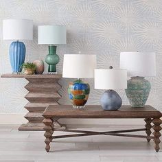 a wooden table topped with lots of vases and lamps