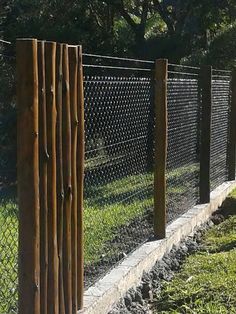 the fence is made out of wood and has metal bars on each side, along with concrete edging