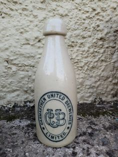 a bottle sitting on the ground next to a wall