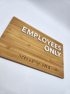 a wooden sign that says employees only on the side of a white wall in an office