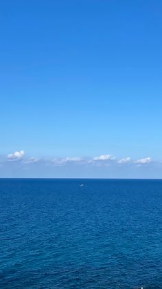 the ocean is blue and clear with some clouds