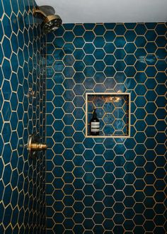 a bathroom with blue and gold tiles on the walls