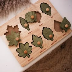 a wooden cutting board with leaves and acorns cut out to look like flowers