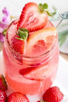 a strawberry lemonade drink is garnished with fresh strawberries