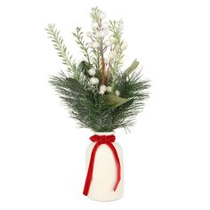 a vase filled with white flowers and greenery on top of a table next to a red ribbon