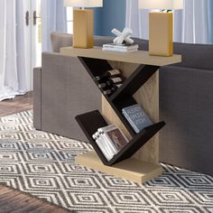 a living room with a couch, table and two lamps on top of the coffee table