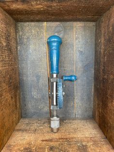 a blue and silver grinder in a wooden storage area with wood planks on the floor