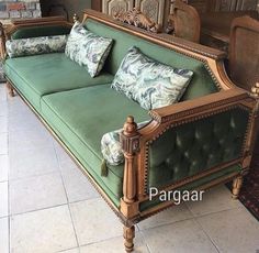 a green couch sitting on top of a tiled floor