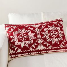 a red and white pillow sitting on top of a couch