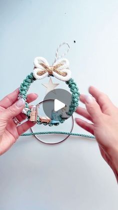 two hands are holding a bracelet with beads and bows