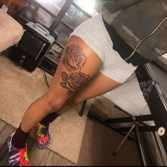 a woman with a rose tattoo on her leg