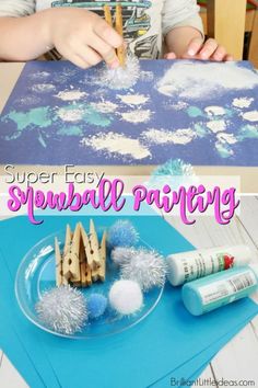 a kid is making snowball painting with popsicle sticks and glue on the table