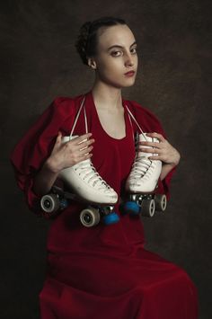 a woman in a red dress holding two roller skates