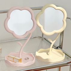 two mirrors sitting on top of a metal shelf