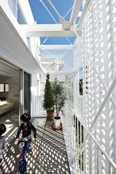 a little boy riding a bike down a long white walkway next to a living room