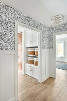 an empty room with white cabinets and blue wallpaper on the walls is pictured in this image