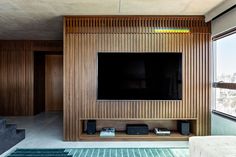 a flat screen tv mounted to the side of a wooden wall in a living room