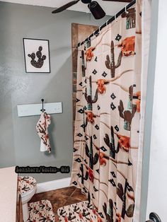 a bathroom with a cactus shower curtain and matching rugs