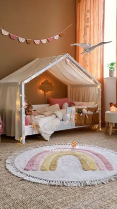 a child's bedroom decorated in pink, white and gold with a canopy bed