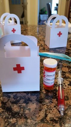 two small boxes with red crosses on them are sitting on a counter next to a bottle of medicine