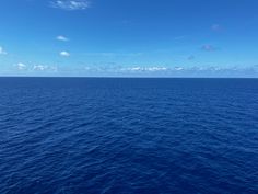 the ocean is very blue with some clouds