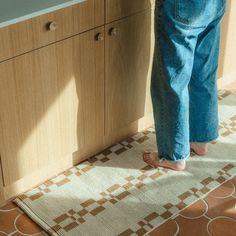 a person standing in front of a kitchen counter with their feet on the counter top