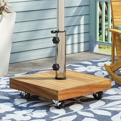 a wooden table sitting on top of a blue rug next to a chair and an umbrella