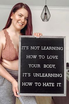 a woman holding up a sign that says it's not learning how to love your body