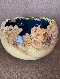 a ceramic bowl sitting on top of a table next to a brown and white wall