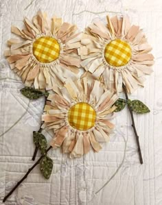 three sunflowers made out of fabric on a quilt