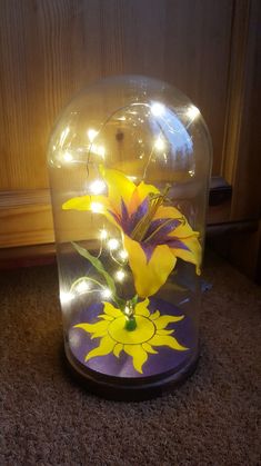 a glass vase with flowers in it sitting on the floor