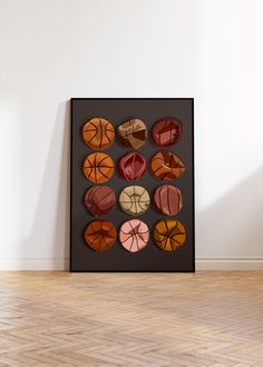 an art piece with basketballs on it in a room next to a wooden floor