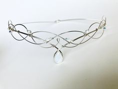 Beautiful handmade silver bridal circlet which is crafted from just two lengths of wire to emulate traditional Celtic knotwork. The circlet features a divine faceted opalite moonstone peardrop centre stone with two small opalite stones above and has small crystals around the sides. Perfect for brides and bridesmaids, handfastings, re-enactment, elven, faerie, or pagan ceremonies. The circlet is open at the back with loops which allow ribbon or cords to be attached. You can also pin the circlet i Moonstone Crown, Moonstone Tiara, Wire Circlet, Amethyst Circlet, Elven Crystal Crown, Silver Circlet Tiara, Wedding Circlet, Elvish Wedding