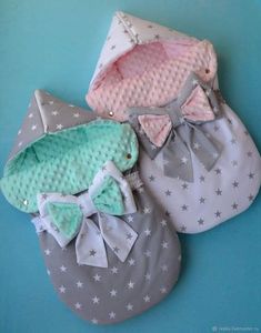 two baby shoes with bows on them sitting next to each other in front of a blue background