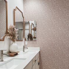 a bathroom with two sinks and mirrors on the wall next to each other in front of a mirror