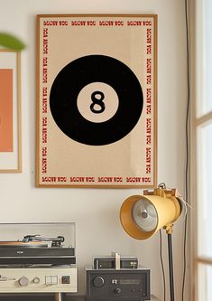 an old record player sits on a table in front of a poster with the number eight