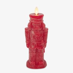 a red candle that is sitting in front of a white background