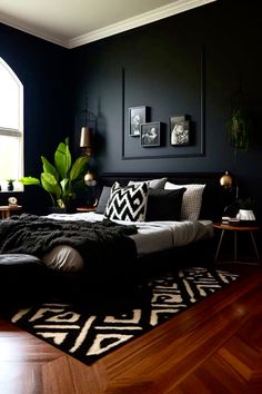 a bedroom with black walls and wooden flooring has a large bed in the middle