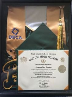 an award plaque is placed in front of a graduation cap and tasseled diploma