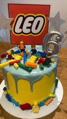 a birthday cake with legos on top and the number six in front of it