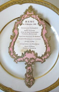 a pink and gold plate with a menu on it