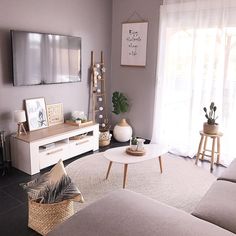 a living room filled with furniture and a flat screen tv mounted to the side of a wall